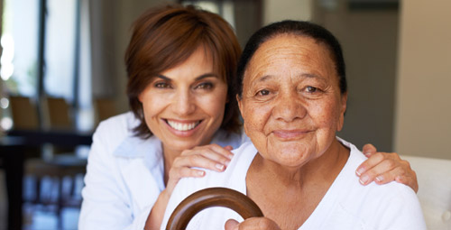 A lady with her hands on the shoulders of the older lady in front of her